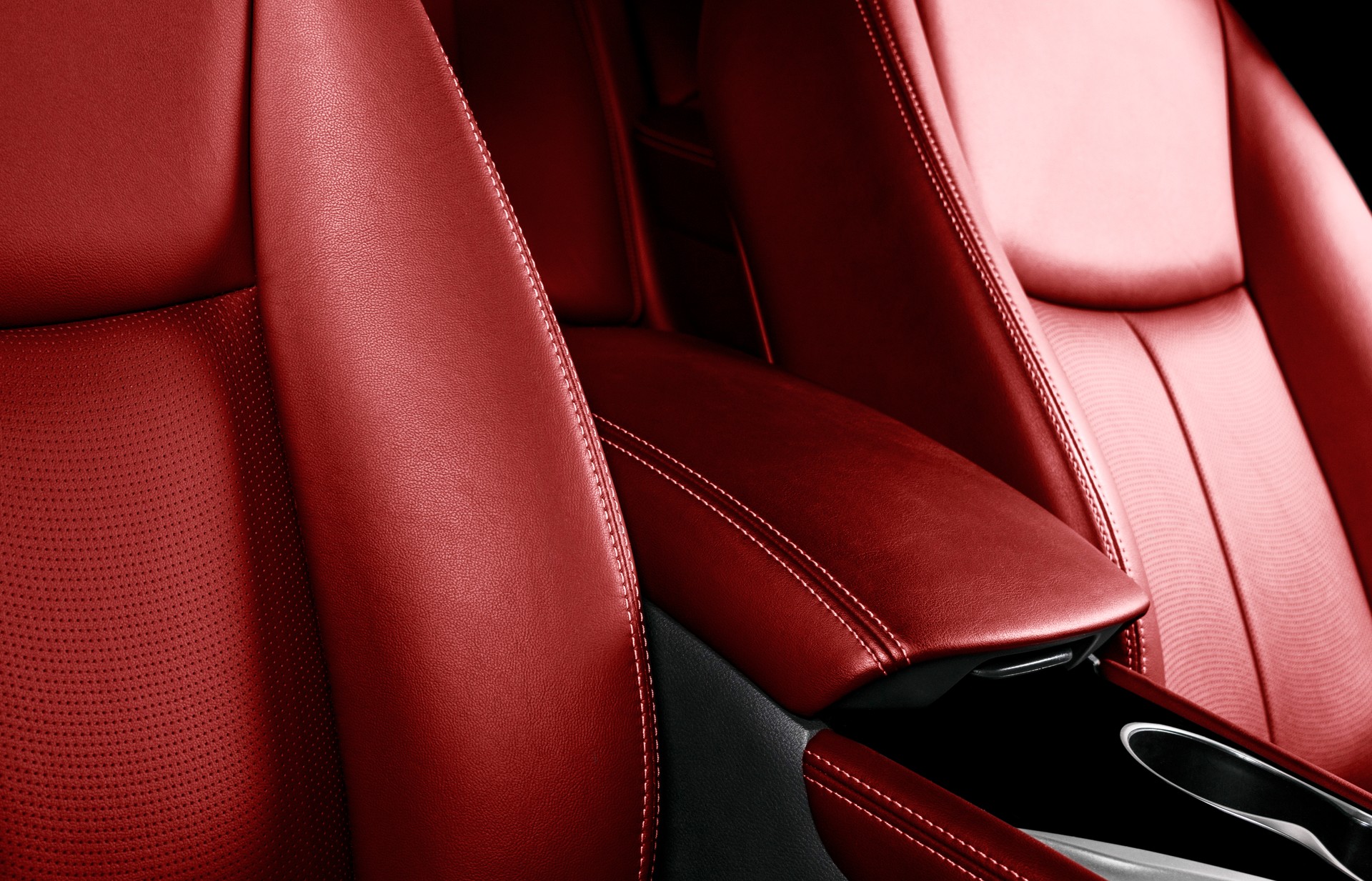 Luxury car red leather interior. Part of leather car seat details with stitching. Comfortable perforated red leather seats. Red perforated leather. Car inside