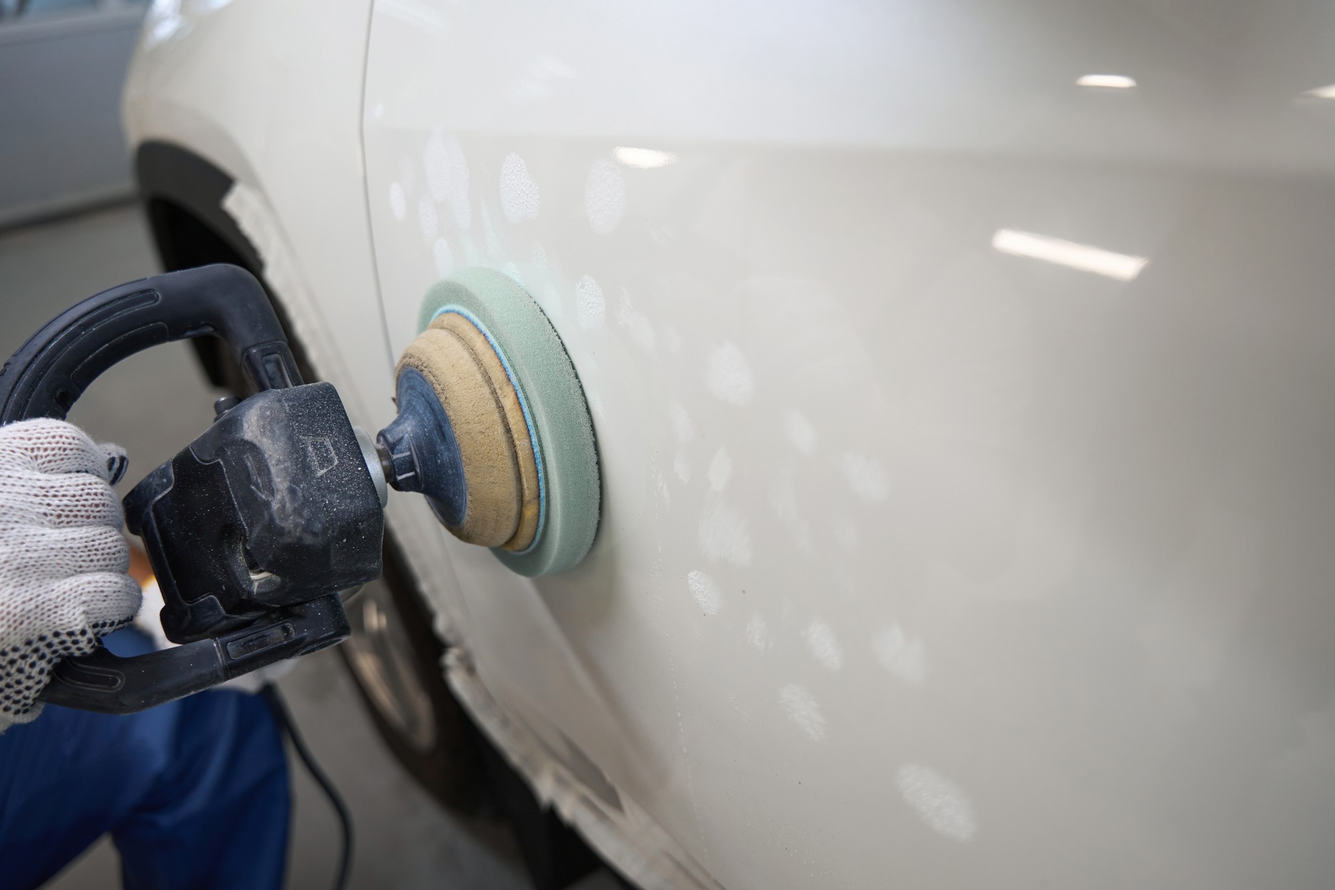 Male polishing car after painting in garage